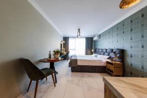 een slaapkamer met een bed, een tafel en een stoel bij Avenue Hotel - Free Parking in Sofia