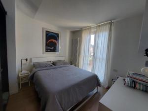 sypialnia z dużym łóżkiem i oknem w obiekcie Mansarda Olgiati zona Navigli w Mediolanie