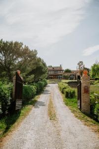 a dirt road with two gates in front of a house at Masseria La Guardata in Guglionesi