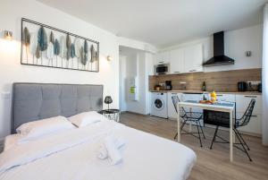 a bedroom with a bed and a table and a kitchen at Dolmen Adrien 2 in Tours