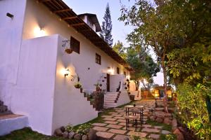 a white house with stairs and tables and chairs at Achalaa Resort in Kolhapur