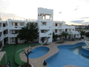 a large apartment building with a large swimming pool at Departamento FORCHE 3ra Bajada al mar in Las Grutas