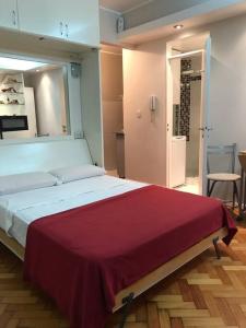 Un dormitorio con una cama grande con una manta roja. en OBELISCO STUDIO en Buenos Aires