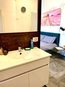 a bathroom with a sink and a mirror and a bed at Sea view cozy apartment in Haifa