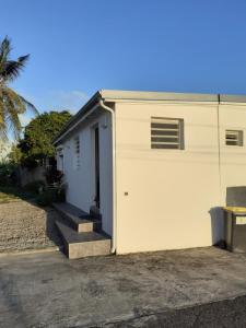 - un garage blanc avec une porte et des escaliers à côté dans l'établissement Belcourt, à Baie-Mahault