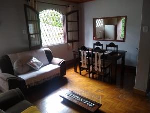 a living room with a couch and a table at Recanto Dorinha in Campos do Jordão