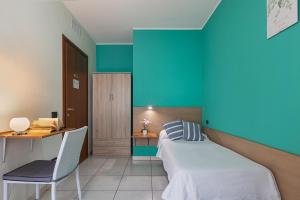 Cette chambre comprend un lit et un bureau. dans l'établissement Ogliastra Apartment Rooms, à Cagliari
