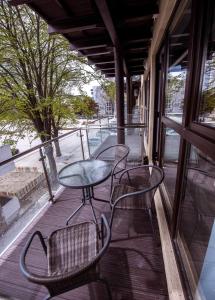 d'un balcon avec des chaises, une table et une fenêtre. dans l'établissement Garsonierele Alexandru, à Saturn