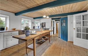 a kitchen with a wooden table and a blue door at 8 Bedroom Beautiful Home In Hjer in Højer