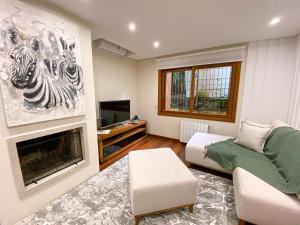 sala de estar con sofá y chimenea en LOCAR-IN GRAMADO - Orquideas 150 m da Rua Coberta, en Gramado