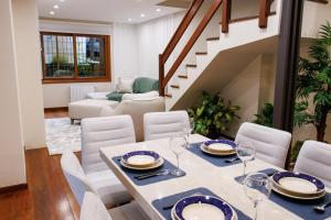 uma sala de jantar com uma mesa e cadeiras e uma escadaria em LOCAR-IN GRAMADO - Orquideas 150 m da Rua Coberta em Gramado