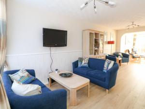 een woonkamer met twee blauwe banken en een tv bij Milton House in Weymouth