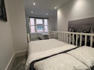 a bedroom with two beds and a window at The Snap Pad Boutique Apartment in Royal Tunbridge Wells