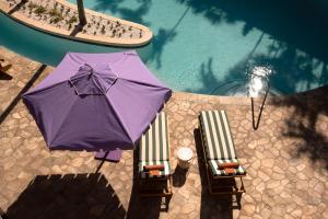 an overhead view of a purple umbrella next to a swimming pool at Wayfinder Waikiki in Honolulu