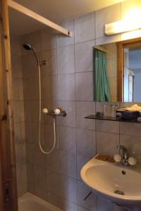 a bathroom with a shower and a sink at Hotel De La Paix in Interlaken
