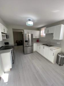 a kitchen with white cabinets and a stainless steel refrigerator at Le Cardinal in Rouyn