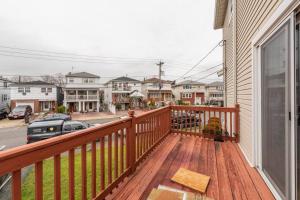 a balcony with a wooden deck with a fire hydrant at A Suburbia-In-The City Colonial Home in Bayonne