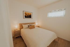 a white bedroom with a bed and a window at Beaufort Street Gem 1br Urban Retreat in Perth