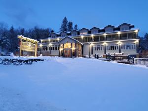 una casa grande en la nieve por la noche en Friends Lake Inn en Chestertown