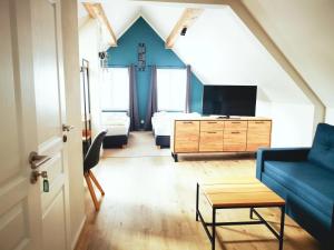 ein Wohnzimmer mit einem blauen Sofa und einem TV in der Unterkunft Rock-inn in Rokytnice nad Jizerou