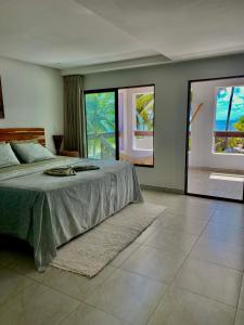 a bedroom with a bed and a large window at Jardim Azul in Pitimbu
