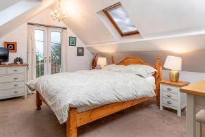 a bedroom with a bed and a desk and a television at Bodfryn Cottage in Llangoed