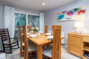 ein Esszimmer mit einem Holztisch und Stühlen in der Unterkunft Bodfryn Cottage in Llangoed