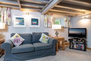 a living room with a couch and a flat screen tv at Bodfryn Cottage in Llangoed