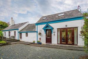 a white house with a blue roof at Bodfryn Cottage in Llangoed