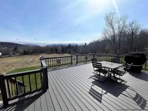 a wooden deck with a picnic table and a grill at Close to skiing and hiking, walk to main street in Tannersville