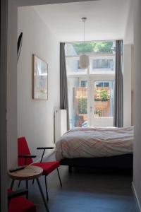 a bedroom with a bed and a table and a window at B&B Central Park in Utrecht