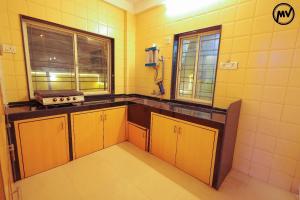 a kitchen with yellow tiled walls and yellow cabinets at Marigold Villa with Swimming pool in Mahabaleshwar