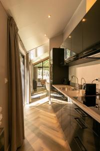 uma cozinha com armários pretos e piso em madeira em Pool Lodge - Vakantiepark de Thijmse Berg em Rhenen