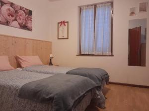 een slaapkamer met 2 bedden en een raam bij Casa dei Tulipani Tenna Ospitar in Tenna 