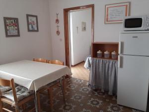 a kitchen with a table and a white refrigerator at Casa dei Tulipani Tenna Ospitar in Tenna 