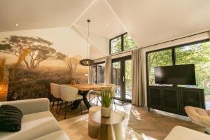 a living room with a couch and a table at Pool Lodge - Vakantiepark De Thijmse Berg in Rhenen