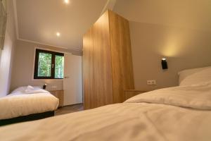 1 dormitorio con 2 camas y ventana en Pool Lodge - Vakantiepark de Thijmse Berg en Rhenen