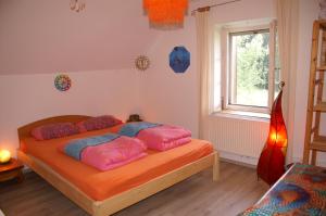 ein Schlafzimmer mit einem Bett mit rosa Kissen darauf in der Unterkunft ruhiges Wohnen am Lama und Maine Coon Hof in Alleinlage in Biederbach 3 Zimmer mit Kochgelegenheit Bad 