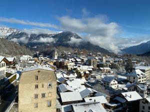 a city with snow covered roofs and a mountain at L'Arpille in Salvan