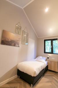 レーネンにあるPool Lodge - Vakantiepark de Thijmse Bergのベッドルーム1室(ベッド1台付)