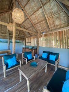 a living room with blue pillows and a wooden table at Sampaguita Villas in El Nido