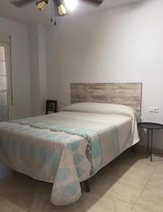 a bedroom with a large bed with a wooden headboard at Piso luminoso cerca de la playa in Roquetas de Mar