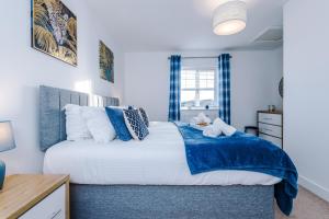 um quarto com uma cama grande e detalhes em azul em Modern 4-Bed Townhouse in Crewe by 53 Degrees Property, Ideal for Contractors & Business, FREE Parking - Sleeps 8 em Crewe