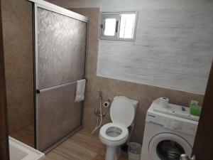 a bathroom with a toilet and a washing machine at Hermosa Casa en Jaureguiberry in Jaureguiberry