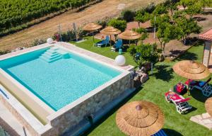 een uitzicht over een zwembad met parasols bij Residenza alla Collina & Romantic SPA in Porto Conte