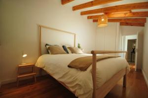 Un dormitorio con una cama grande en una habitación con techos de madera. en Casas de Santiago, en Vila Nova de Cerveira