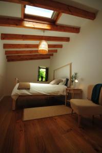 - une chambre avec un lit dans une pièce dotée de plafonds en bois dans l'établissement Casas de Santiago, à Vila Nova de Cerveira