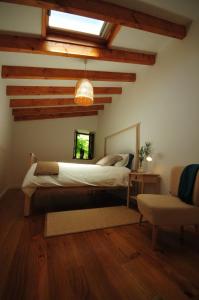 a bedroom with a bed in a room with wooden ceilings at Casas de Santiago in Vila Nova de Cerveira