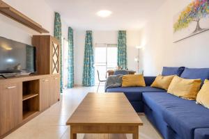 salon z niebieską kanapą i telewizorem w obiekcie Apartamento Carabeo 2000 Nº5 w mieście Nerja