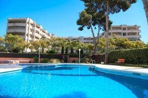 una gran piscina azul frente a un edificio en UHC Buigas Luz Apartments, en Salou